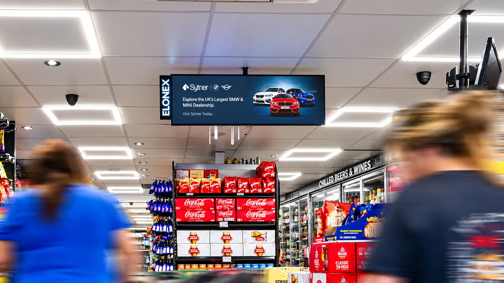 Digital promotional screens inside a UK convenience store